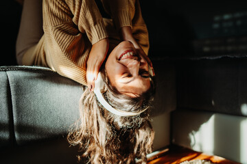Young caucasian woman enjoying music on wireless headphones at home	