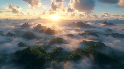 Fototapeta premium A breathtaking aerial view of lush green mountains enveloped in soft clouds, illuminated by the golden glow of the setting sun, creating a serene and ethereal atmosphere.