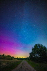 	
Long time exposure night landscape with road, Milky Way galaxy on the sky during the Meteor Shower Perseids and Aurora Borealis or Northern lights. Shooting star. Colorful sky