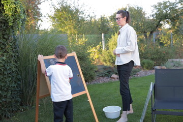 Homeschooling. Woman teaching a boy at home