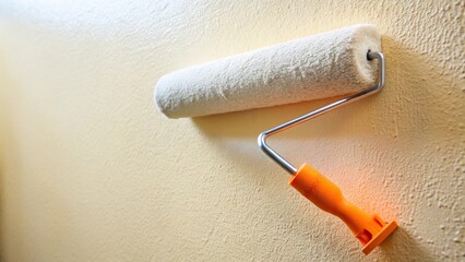 Obraz premium Wide-angle paint roller painting wall with structural paint