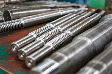 Metal blanks and products arranged in an industrial workshop with tools and machinery during daytime operations