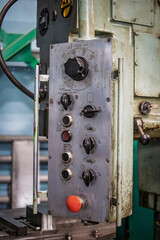 Control panel of an industrial milling machine in a manufacturing facility, showcasing various settings and operational buttons