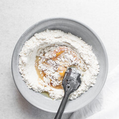 top view of mooncake dough being mixed, Overhead view of homemade mooncake dough in a grey bowl, process of making mooncakes for Lunar New Year and mid-autumn festival