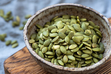 Pepitas, raw dry pumpkin seeds in a bowl closeup view