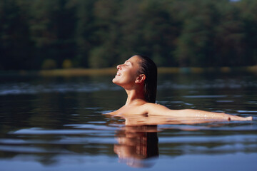 Fototapeta premium Woman in nature swimming in the lake