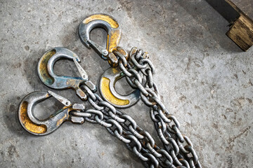 Lifting device with three hooks and heavy-duty chain for transporting loads in an industrial workshop environment