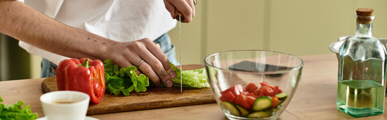 In a modern kitchen, a handsome young man skillfully makes a vibrant salad for healthy living.