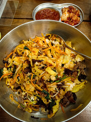 Bibimbap is a dish containing rice, fresh vegetables, meat, and eggs mixed with gochujang paste.