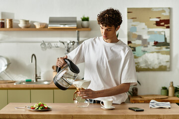 In a contemporary kitchen, a handsome young man pours coffee from a kettle into a glass, enjoying culinary moments.
