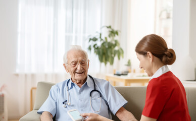The  measuring blood sugar levels in elderly people in a nursing home with an elderly man holding a glucose monitor