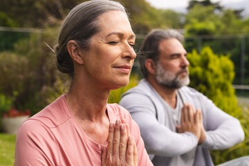 Fototapeta premium Mature couple meditating outdoors, enjoying peaceful moment in nature together