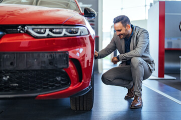 Businessman Inspecting New Car at Dealership Showroom