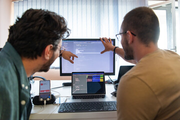 Programmers engrossed in deep collaboration, diligently working together to solve complex problems...
