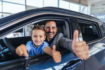 Father and Son Smiling in New Car at Dealership