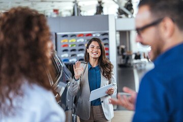 Friendly Car Saleswoman Welcoming Customers at Showroom Entrance