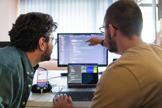 Programmers engrossed in deep collaboration, diligently working together to solve complex problems and develop innovative mobile applications with seamless functionality.
