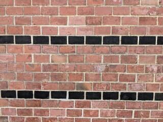 Architectural brickwork with alternating red and black bricks in a strip pattern typical of first...