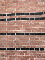 Architectural brickwork with alternating red and black bricks in a strip pattern typical of first...