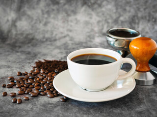 Coffee cup and beans with ground coffee on  gray background, Black coffee cup aromatic and making equipment, Tamper, Filter Basket