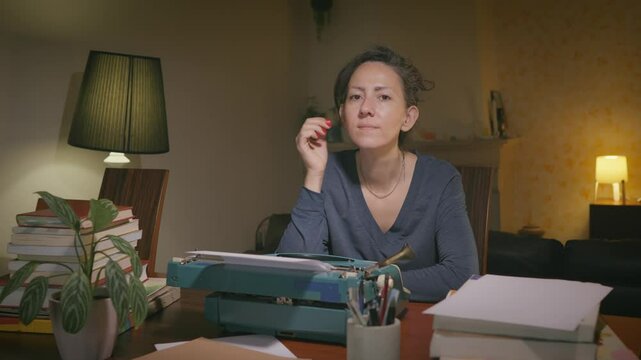 A dedicated writer craftily types on an old-fashioned typewriter, surrounded by books and papers, in a cozy, softly-lit room. The ambiance promotes creativity and focus.
