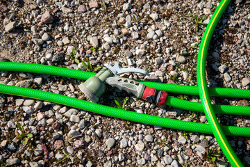 Garden watering hose on rocky ground