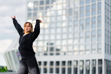 Young dancer performs an expressive routine in an urban setting at dusk