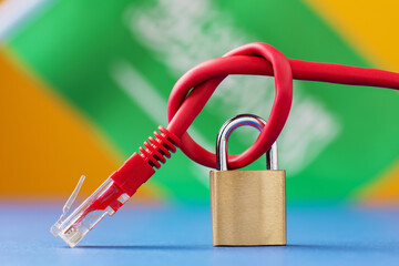 A closed lock on a tied network wire in a knot on the background of the Saudi Arabian flag, the concept of security of Internet technologies in the country