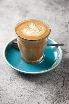 Latte on blue saucer with teaspoon
