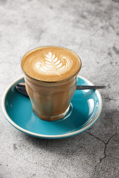Latte on blue saucer with teaspoon