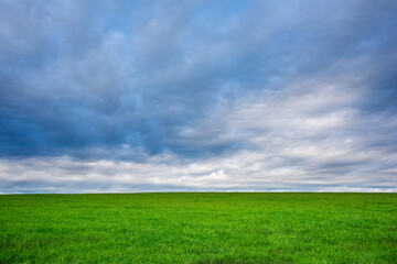 Open Green Field Under a Dramatic Cloudy Sky