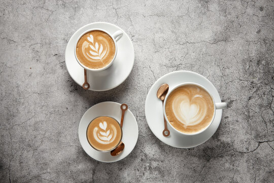 Three coffees on saucers with teaspoons