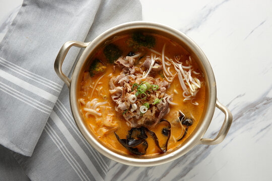 Beef laksa noodle soup with broccoli, dried seaweed, and spring onions