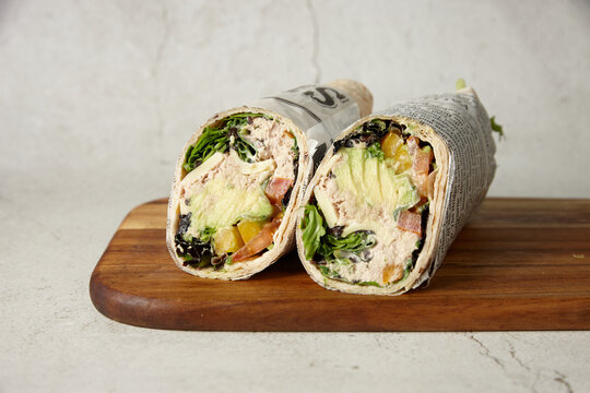 Tuna avocado wrap served on a wooden board