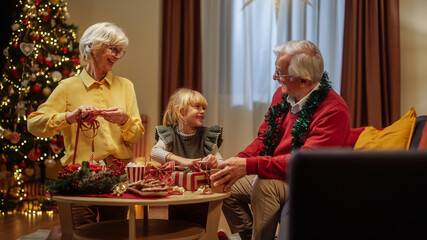 Granddaughter decorating present with grandparents