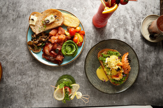two full breakfast plates with fruit drinks on the sides