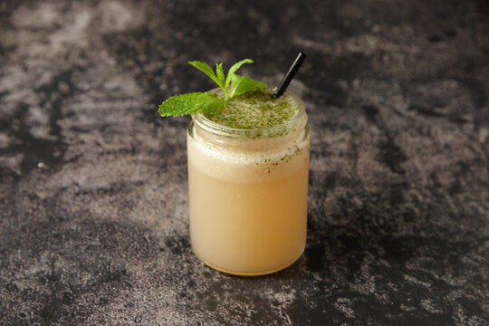 Close up of tomi punch with black straw and mint