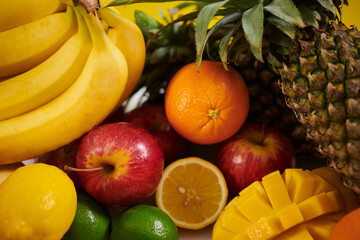 Close-up of diverse tropical fruits including bananas, pineapple, oranges, and apples arranged creatively. Capture emphasizes freshness and variety of natural textures