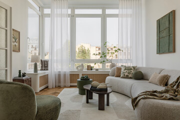 Bright, cozy living room with natural light, lush plants, and soft textures, creating an inviting...