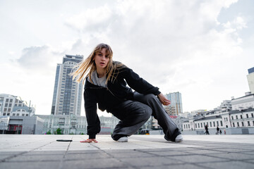 Young dancer practicing breakdancing moves on urban plaza during daytime