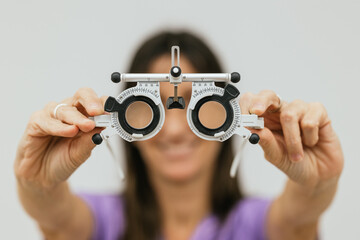 Female optometrist holding trial frame for pediatric eye exam