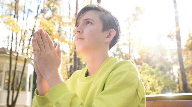 boy is praying in autumn park	