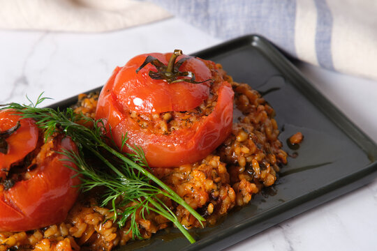 large tomatoes stuffed with rice and green garnish on top