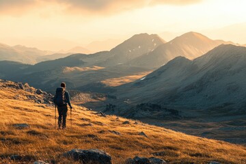 A lone hiker walks towards the sunset over a vast mountain range. The image depicts the beauty and solitude of nature, making it ideal for travel, adventure, and exploration themes.