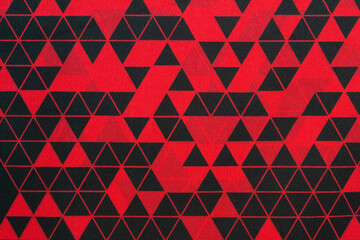 fabric texture with an abstract pattern of red color with black triangles