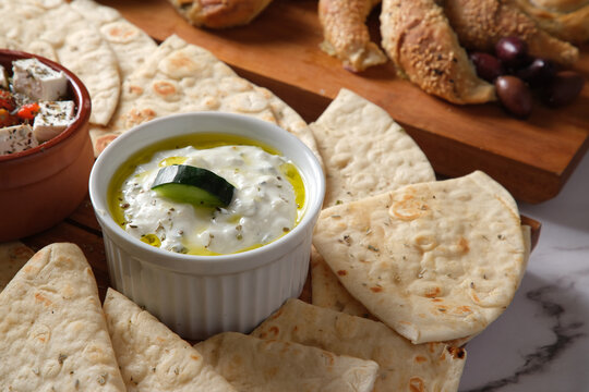 A plate of pita bread with dips and side dishes