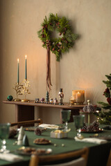 Aesthetic composition of christmas living room interior with wooden console, christmas gifts, candle with candlestick, christmas tree, and personal accessories. Home decor. Template.	