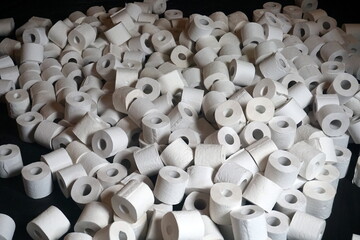 A pile of many white toilet paper on a black background. group of many rolls of toilet paper. A lot...