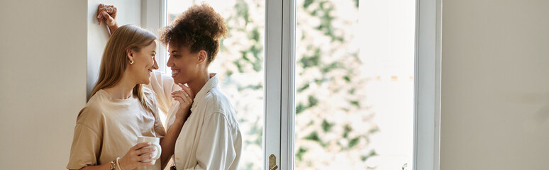 Two partners share a tender moment by the window, surrounded by natural light.