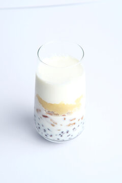 Homemade milk bubble tea with tapioca pearls and mango in a tall glass
